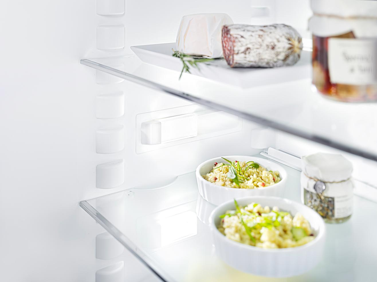 Foto eines Kühlschrankdetails mit Lebensmitteln. Innenbeleuchtung fotografiert mit Fachkamera und bewusster Schärfe-Verlagerung